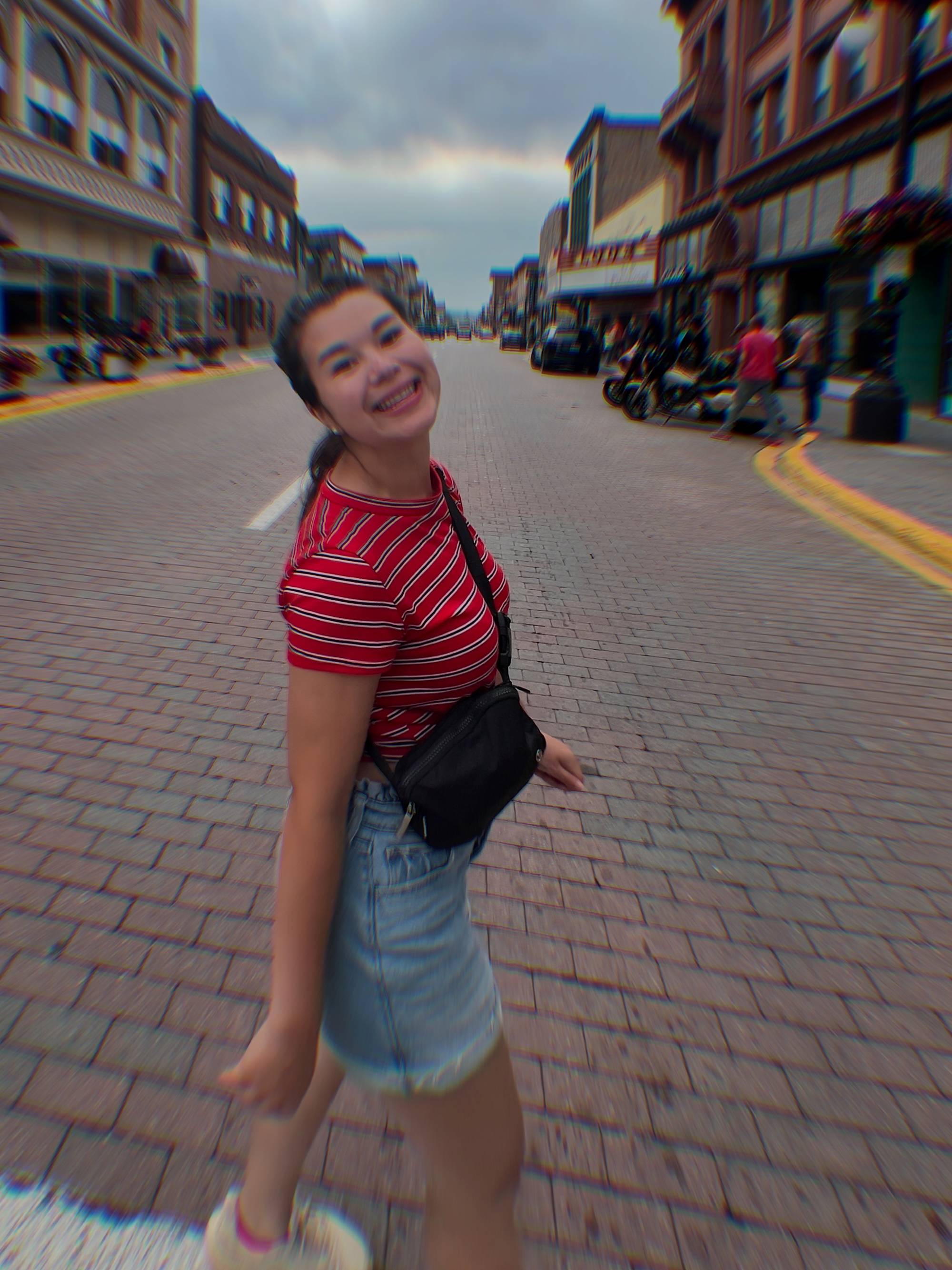 Girl standing under trees decorated with lights